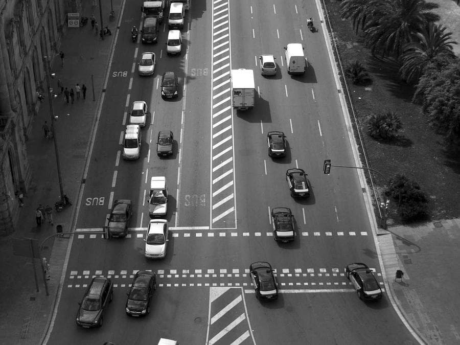 Three boys mid-sprint, silhouetted against a bright surf line, bodies leaning forward in motion